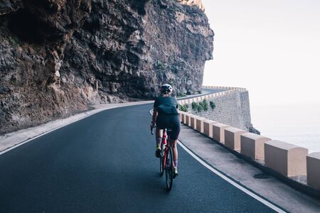 Cyclist riding a bike on an open road on Tenerife Islandの写真素材
