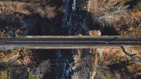 Beautiful misty morning view of a bridge over the railway connection over the river in the mountainの写真素材