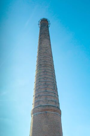 old brick chimney on background of blue skyの写真素材