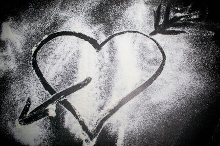 heart broken by an arrow on a black backgroundの写真素材