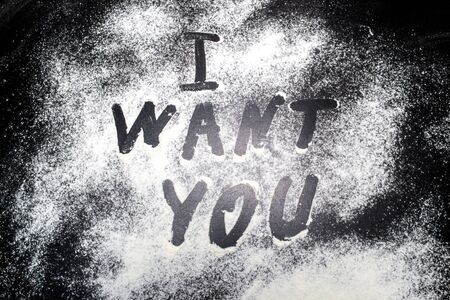 Inscription I WANT YOU made of flour on a black backgroundの写真素材