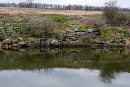 Gray rocks with green moss ... eflection in the riverの写真素材