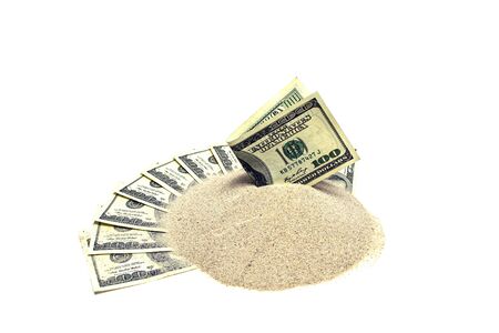Dollar in a heap of sand on dollars isolated on a white backgroundの写真素材