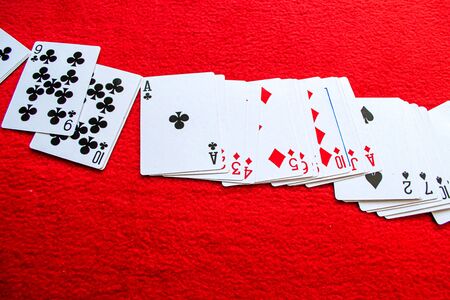scattered deck of cards on a red backgroundの写真素材