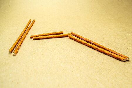 Pretzel sticks in zigzag pairs on a beige background
