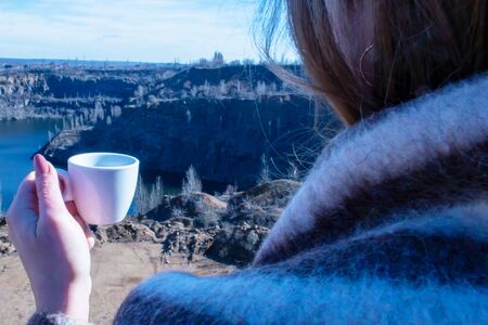 Woman with a cup of coffee on a canyon backgroundの写真素材