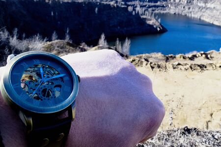 Male hand in a watch against the background of canyonの写真素材