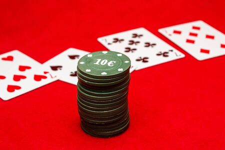 Playing cards and poker chip on a red backgroundの写真素材
