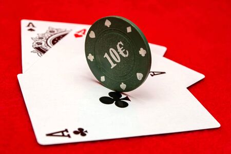 Poker chips and cards on red background