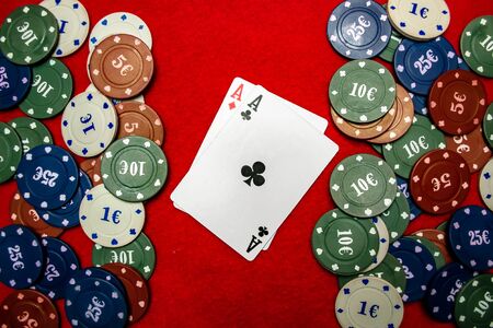Poker chips and in the middle two aces on a red background