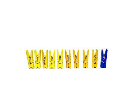 Clothespins are yellow and one blue isolated on a white backgroundの写真素材