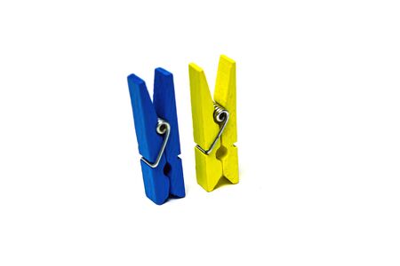 Two clothespins stand yellow and blue isolated on white background