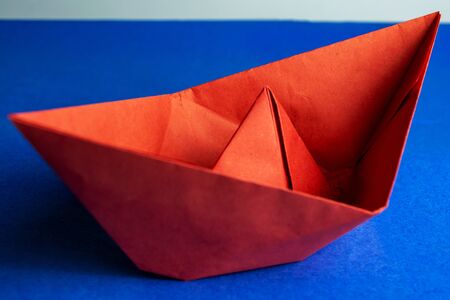 Red paper boat on a blue backgroundの写真素材