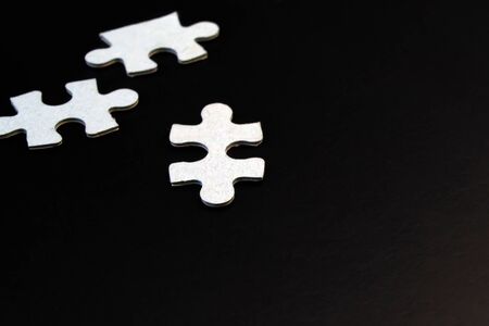 Three white puzzles on a black backgroundの写真素材