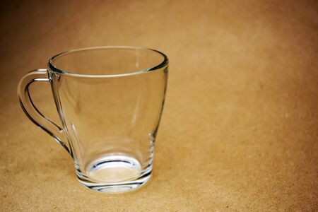 Empty transparent glass cup on a beige backgroundの写真素材