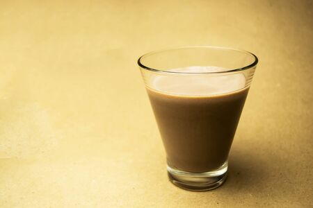 Cocoa milk in a glass cup on a beige backgroundの写真素材