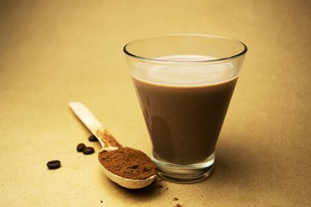 Cocoa milk and a wooden spoon with cocoa powderの写真素材