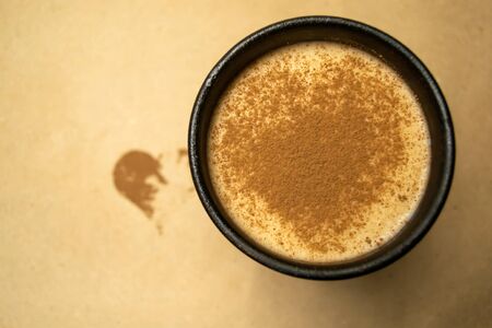 Cocoa milk in a clay cup, heart made of cocoa powderの写真素材