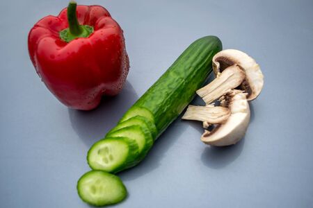 Red juicy bell pepper, green cucumber, mushroomsの写真素材
