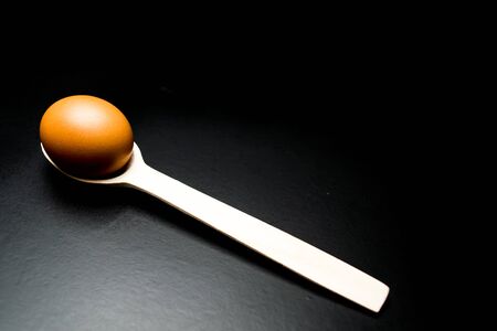 Chicken egg on a wooden spoonの写真素材