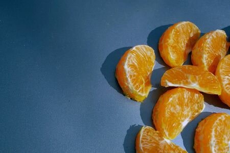 Pieces of orange mandarin on a gray backgroundの写真素材