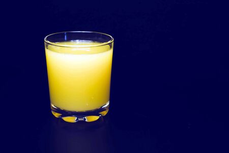 A glass of freshly squeezed tangerine juice. Black background.の写真素材