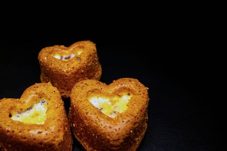 Heart shaped sponge cake. Bakery products. Black background.の写真素材
