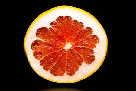Ripe juicy grapefruit on a black background