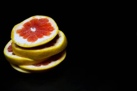 Ripe juicy grapefruit on a black backgroundの写真素材