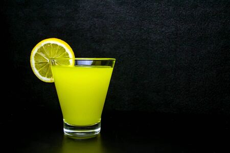 Lemonade in a glass of lemon slice on a black background.の写真素材