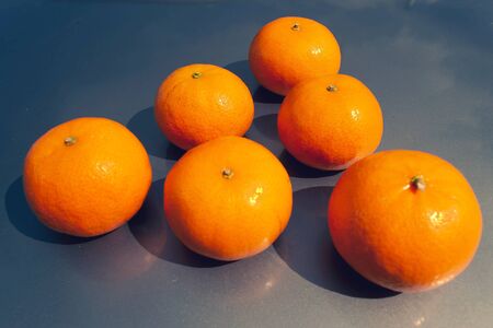 Lots of ripe juicy tangerines on a blue backgroundの写真素材