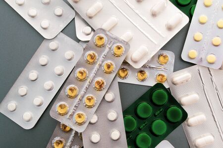 Pills, capsules, vaccine syringe medicines on gray background