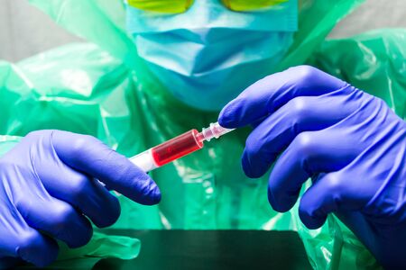 Doctor, researcher or scientist hand in blue glove holding flu, measles, rubella or hpv vaccine and...
