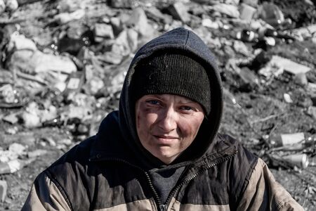 Dirty homeless woman on the background of landfillの写真素材