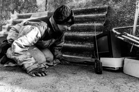 Homeless dirty woman listens to radio musicの写真素材