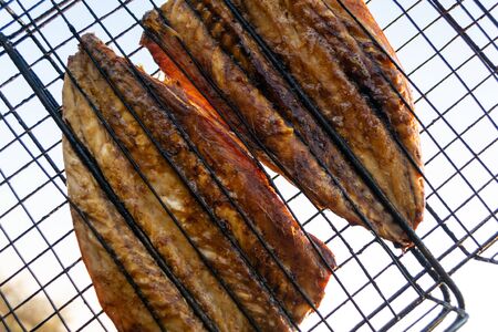 Baked mackerel fish on a fire. Mesh on the grill.の写真素材
