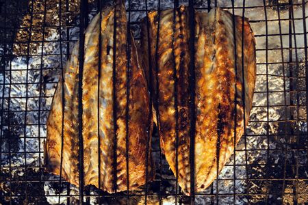 Baked mackerel fish on a fire. Mesh on the grill.