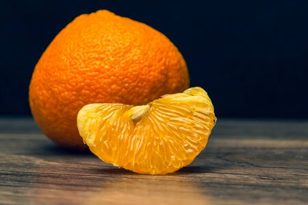Fresh juicy tangerine on a wooden background. Mandarin slices