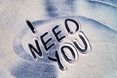 The inscription I need you is written in closeup on sea sand.の写真素材