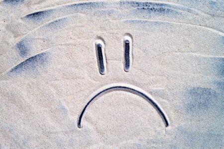 Smiley painted on the sea sand close upの写真素材