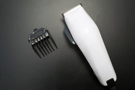 Stylish professional hairdresser hair clippers, hair clippers, accessories for haircuts on a black...