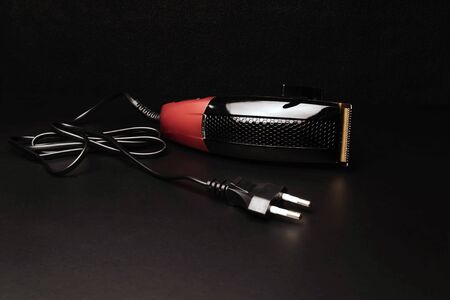 Stylish professional hairdresser hair clippers, hair clippers, accessories for haircuts on a black...