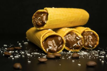 Wafer rolls with condensed milk on a black backgroundの写真素材