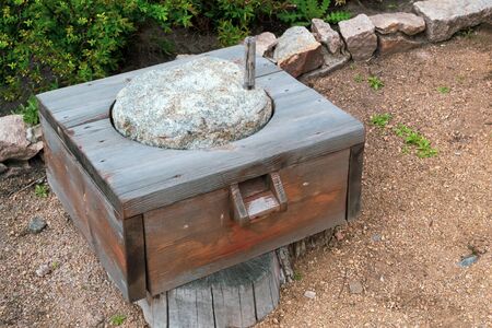 Old wooden mill with stones for grain