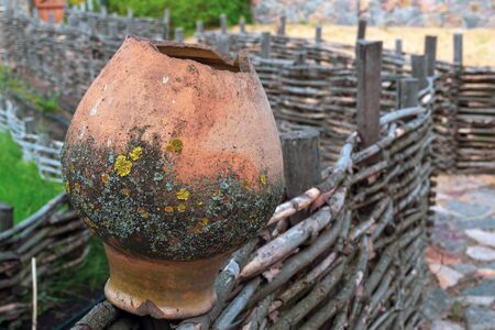 Clay jug hanging on a wooden parkの写真素材