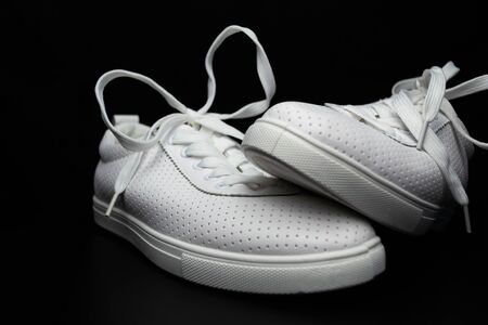 White sneakers on a black background. Sport shoes.