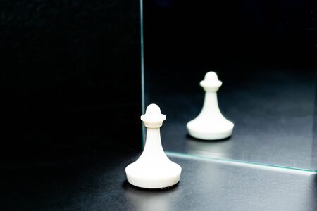 Chess figure and mirror on a black background