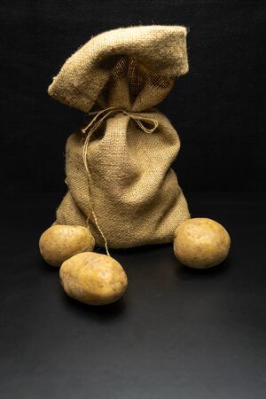 Potatoes on a black background ,bag of potatoesの写真素材