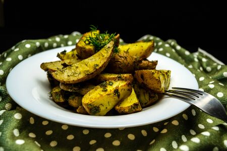 Sliced potatoes and sprinkled with herbs in a white plate