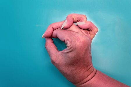 Hand of a man on a blue background close upの写真素材
